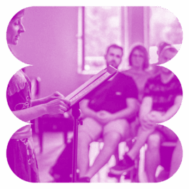 Frau an Pult vortragend vor Publikum